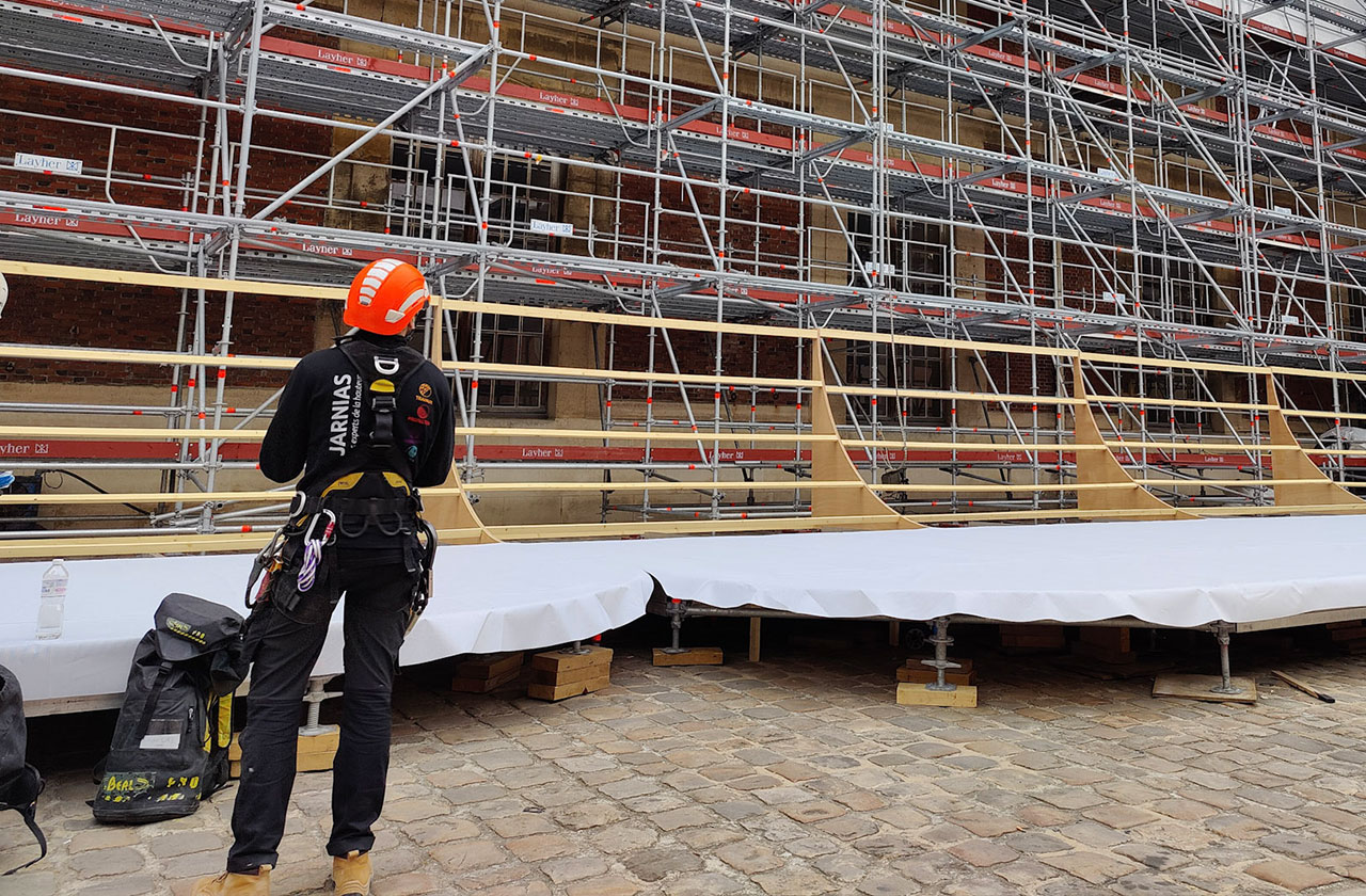 travailleur équipé d’un harnais de sécurité devant un échafaudage